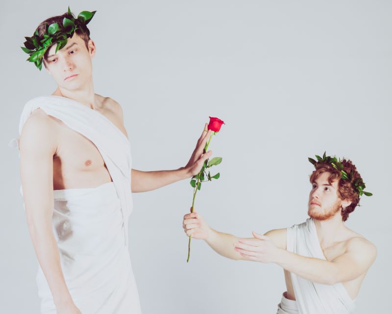 toga man rejecting rose from another toga man